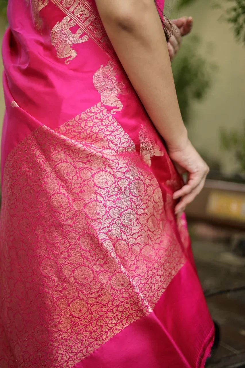 Close-up of a pink saree with intricate gold patterns, blurred background
