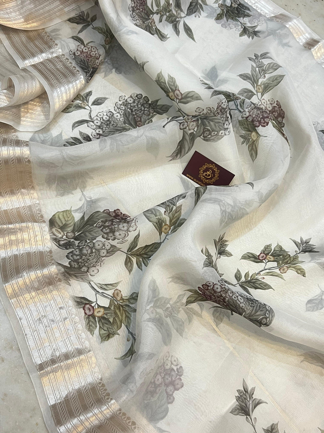 Pure Banarasi Kora silk saree with floral digital print, silver zari Banarasi border, and matching Chiniya silk blouse piece—ideal for festive and elegant occasions.