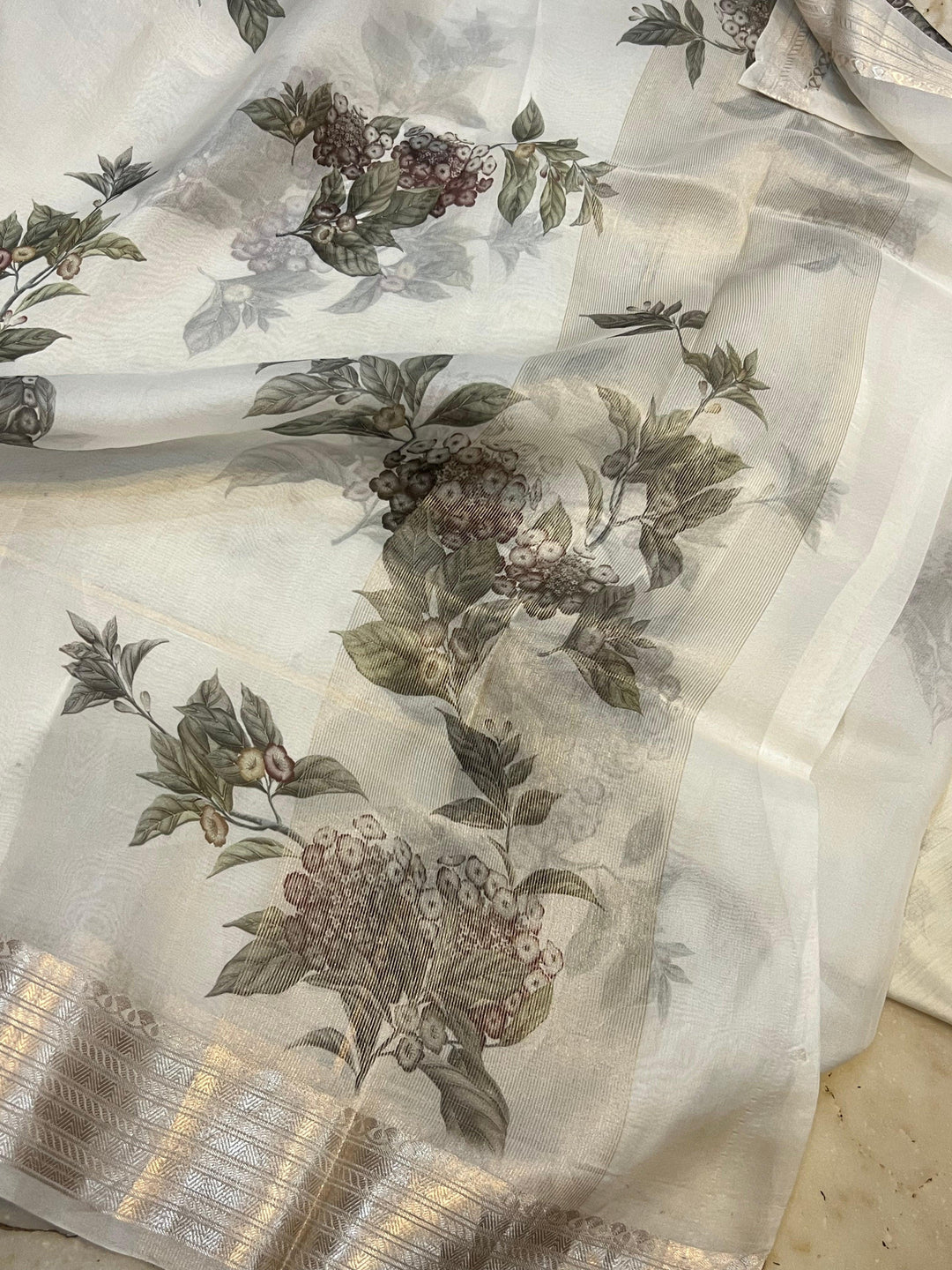 Pure Banarasi Kora silk saree with floral digital print, silver zari Banarasi border, and matching Chiniya silk blouse piece—ideal for festive and elegant occasions.