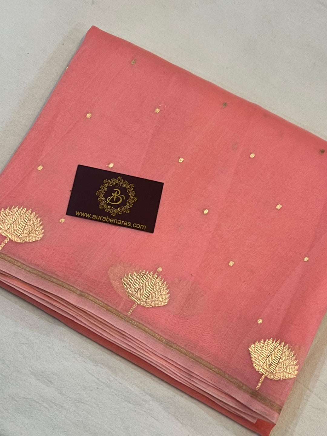 Pure Banarasi handloom Kora silk saree by Aura Benaras with small Kadhwa butis, a designer Banarasi border with Kadhwa butas, and silk blouse featuring golden zari stripes—ideal for weddings and festive wear.