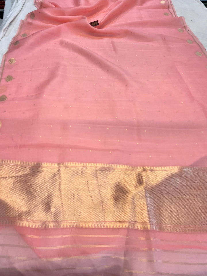 Pure Banarasi handloom Kora silk saree by Aura Benaras with small Kadhwa butis, a designer Banarasi border with Kadhwa butas, and silk blouse featuring golden zari stripes—ideal for weddings and festive wear.