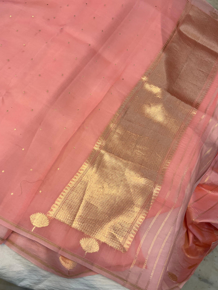 Pure Banarasi handloom Kora silk saree by Aura Benaras with small Kadhwa butis, a designer Banarasi border with Kadhwa butas, and silk blouse featuring golden zari stripes—ideal for weddings and festive wear.