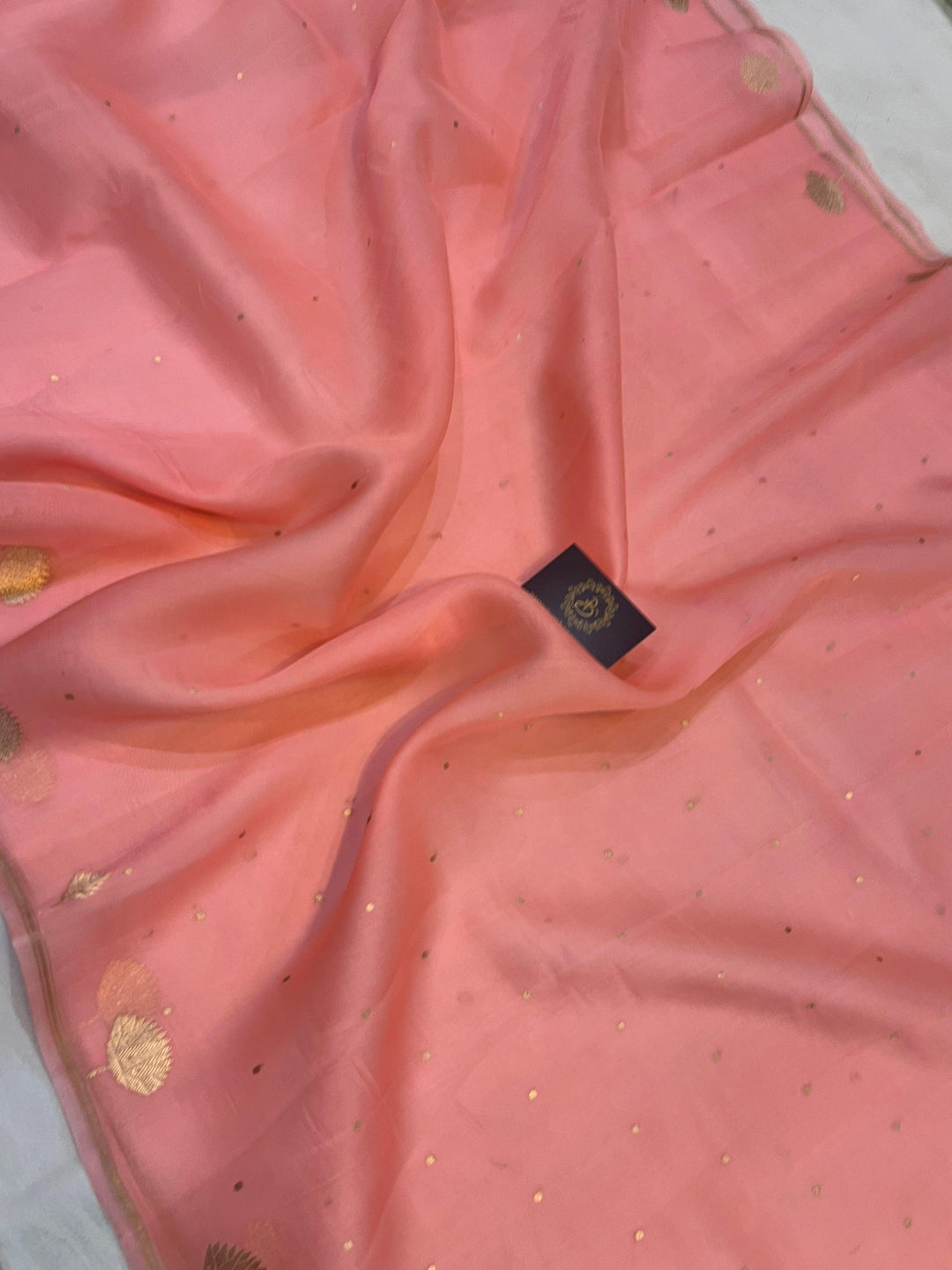 Pure Banarasi handloom Kora silk saree by Aura Benaras with small Kadhwa butis, a designer Banarasi border with Kadhwa butas, and silk blouse featuring golden zari stripes—ideal for weddings and festive wear.