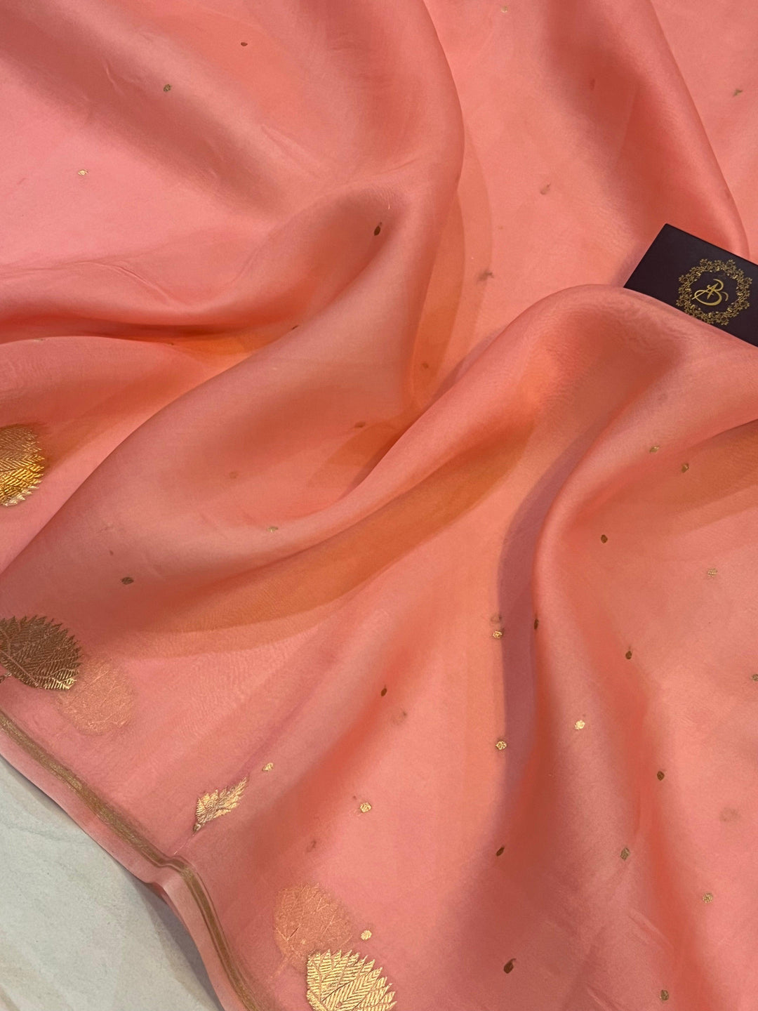 Pure Banarasi handloom Kora silk saree by Aura Benaras with small Kadhwa butis, a designer Banarasi border with Kadhwa butas, and silk blouse featuring golden zari stripes—ideal for weddings and festive wear.