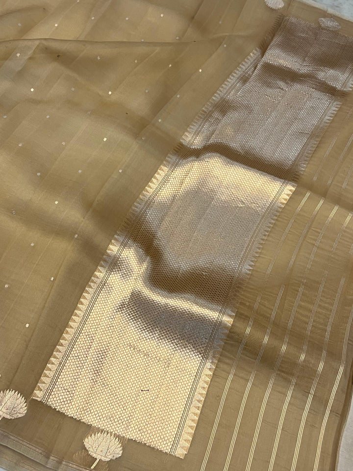 Pure Banarasi handloom Kora silk saree by Aura Benaras with small Kadhwa butis, a designer Banarasi border with Kadhwa butas, and silk blouse featuring golden zari stripes—ideal for weddings and festive wear.