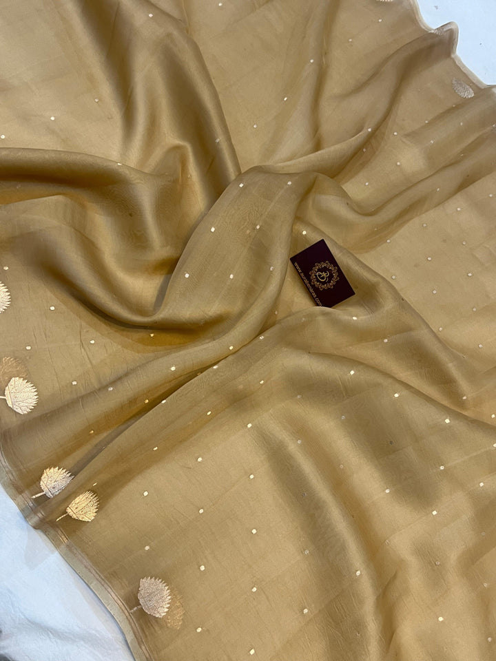 Pure Banarasi handloom Kora silk saree by Aura Benaras with small Kadhwa butis, a designer Banarasi border with Kadhwa butas, and silk blouse featuring golden zari stripes—ideal for weddings and festive wear.