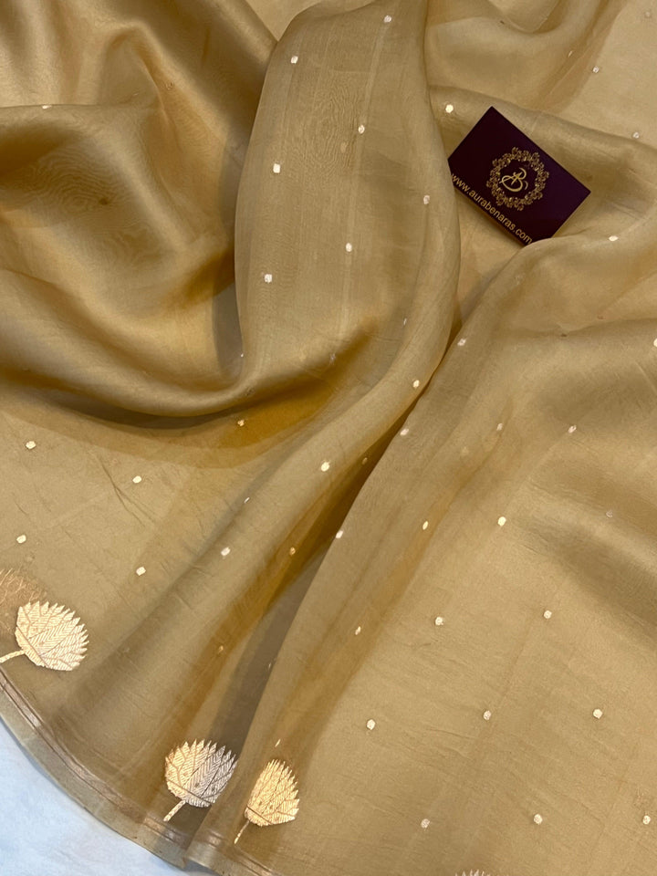 Pure Banarasi handloom Kora silk saree by Aura Benaras with small Kadhwa butis, a designer Banarasi border with Kadhwa butas, and silk blouse featuring golden zari stripes—ideal for weddings and festive wear.