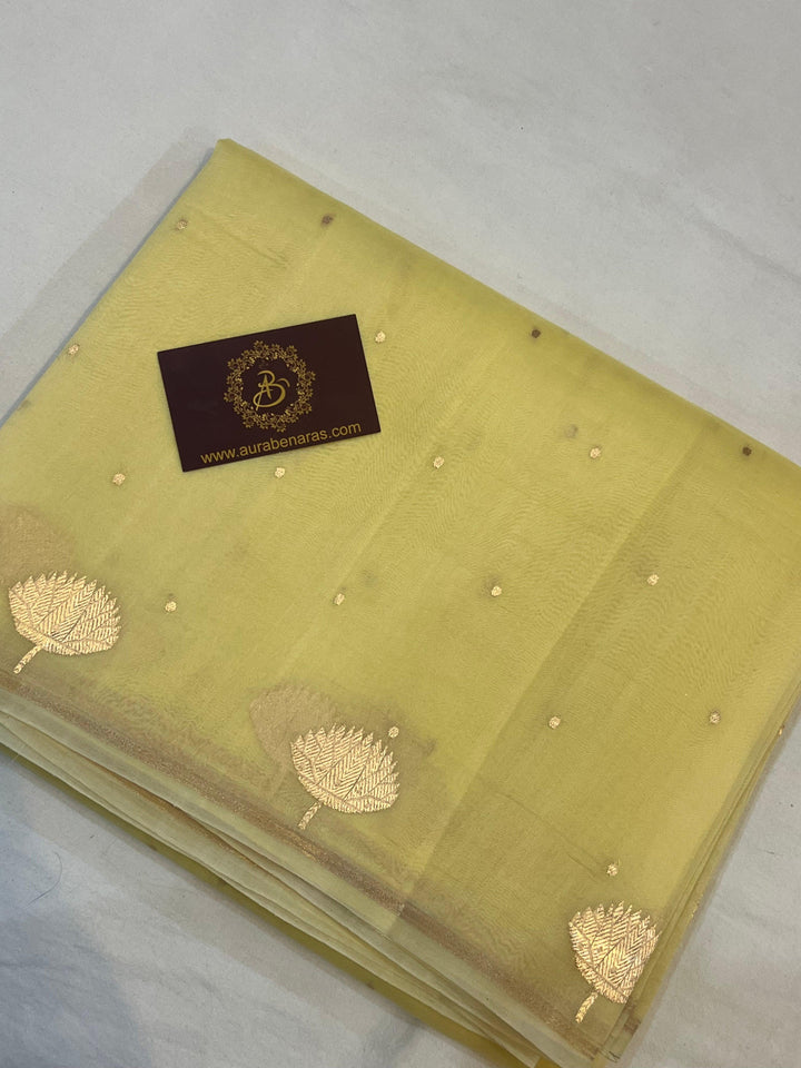 Pure Banarasi handloom Kora silk saree by Aura Benaras with small Kadhwa butis, a designer Banarasi border with Kadhwa butas, and silk blouse featuring golden zari stripes—ideal for weddings and festive