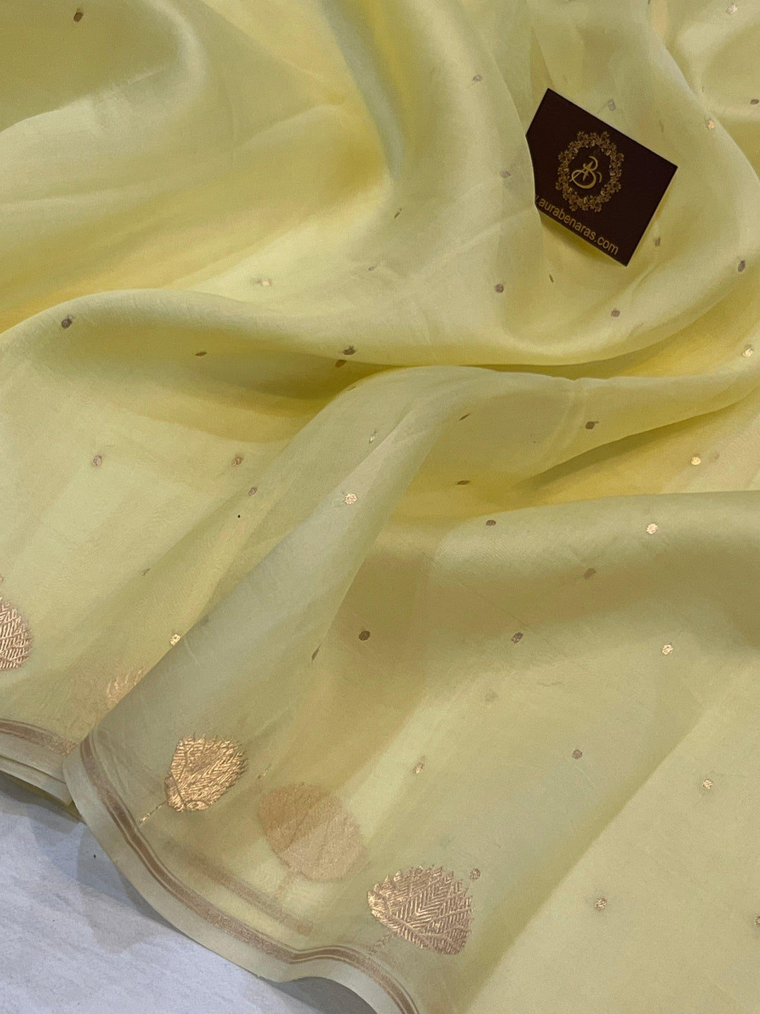 Pure Banarasi handloom Kora silk saree by Aura Benaras with small Kadhwa butis, a designer Banarasi border with Kadhwa butas, and silk blouse featuring golden zari stripes—ideal for weddings and festive