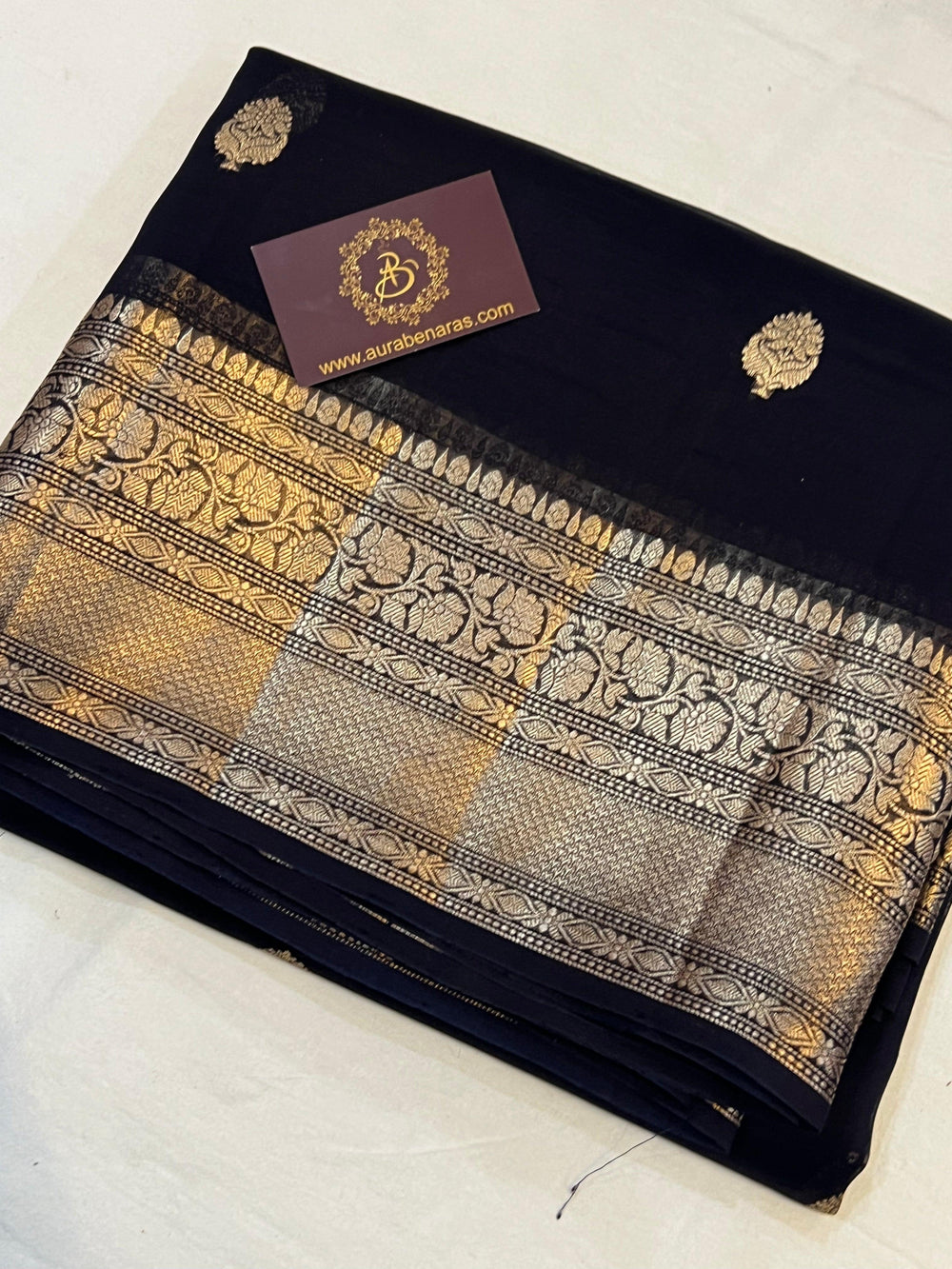Pure Banarasi handloom Kora silk saree by Aura Benaras, featuring intricate Kadhwa butas and a beautiful traditional Banarasi border—ideal for weddings, festive wear, and special occasions.