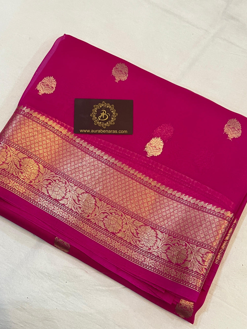 Pure Banarasi handloom Kora silk saree by Aura Benaras, featuring intricate Kadhwa butas and a beautiful traditional Banarasi border—ideal for weddings, festive wear, and special occasions.