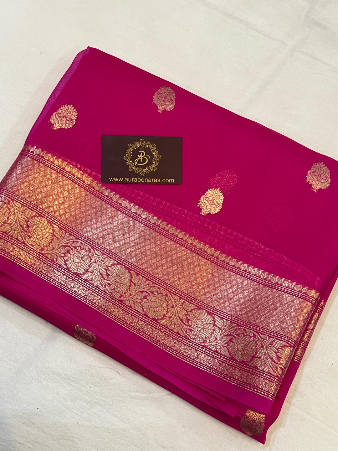 Pure Banarasi handloom Kora silk saree by Aura Benaras, featuring intricate Kadhwa butas and a beautiful traditional Banarasi border—ideal for weddings, festive wear, and special occasions.