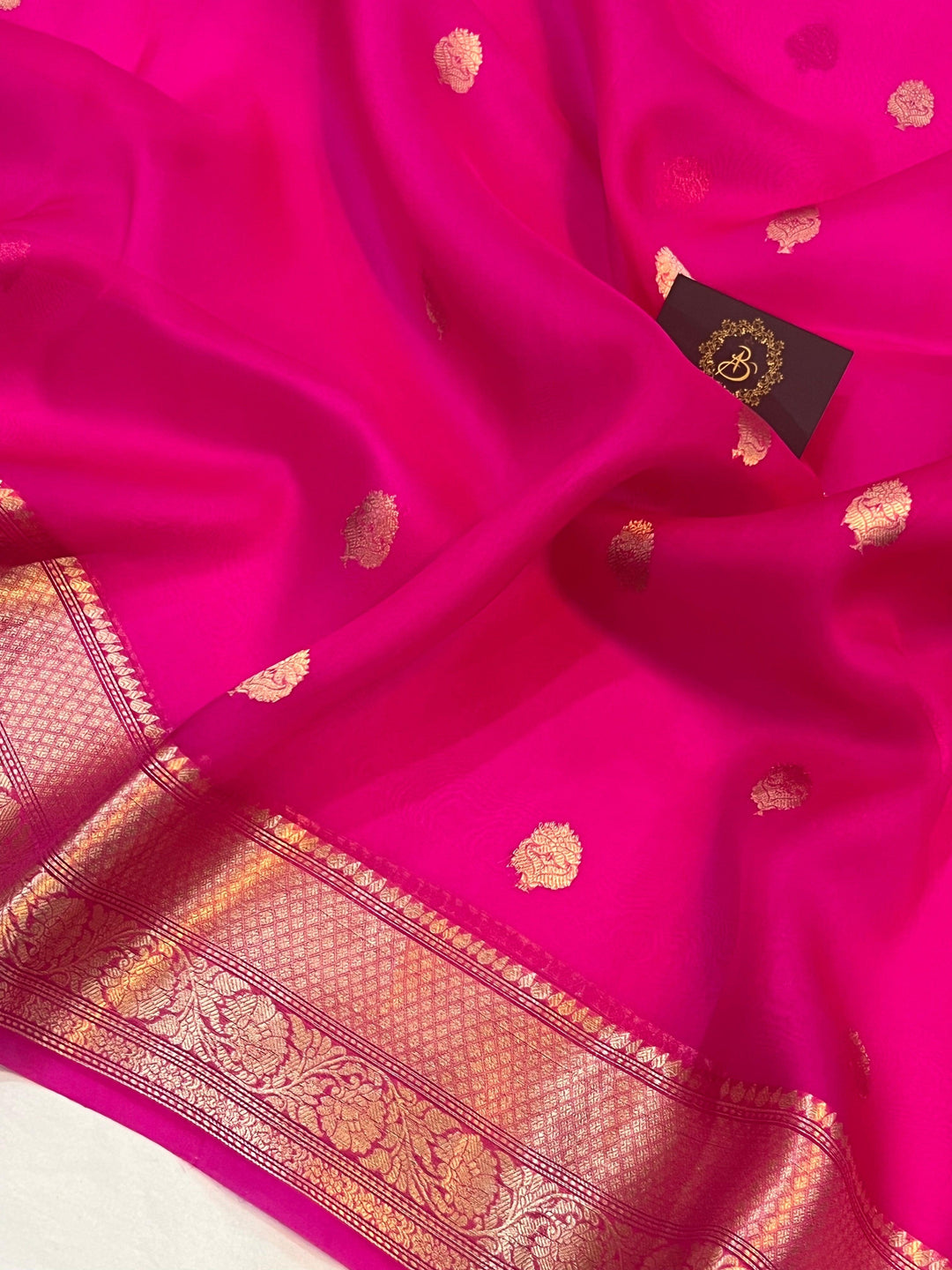 Pure Banarasi handloom Kora silk saree by Aura Benaras, featuring intricate Kadhwa butas and a beautiful traditional Banarasi border—ideal for weddings, festive wear, and special occasions.