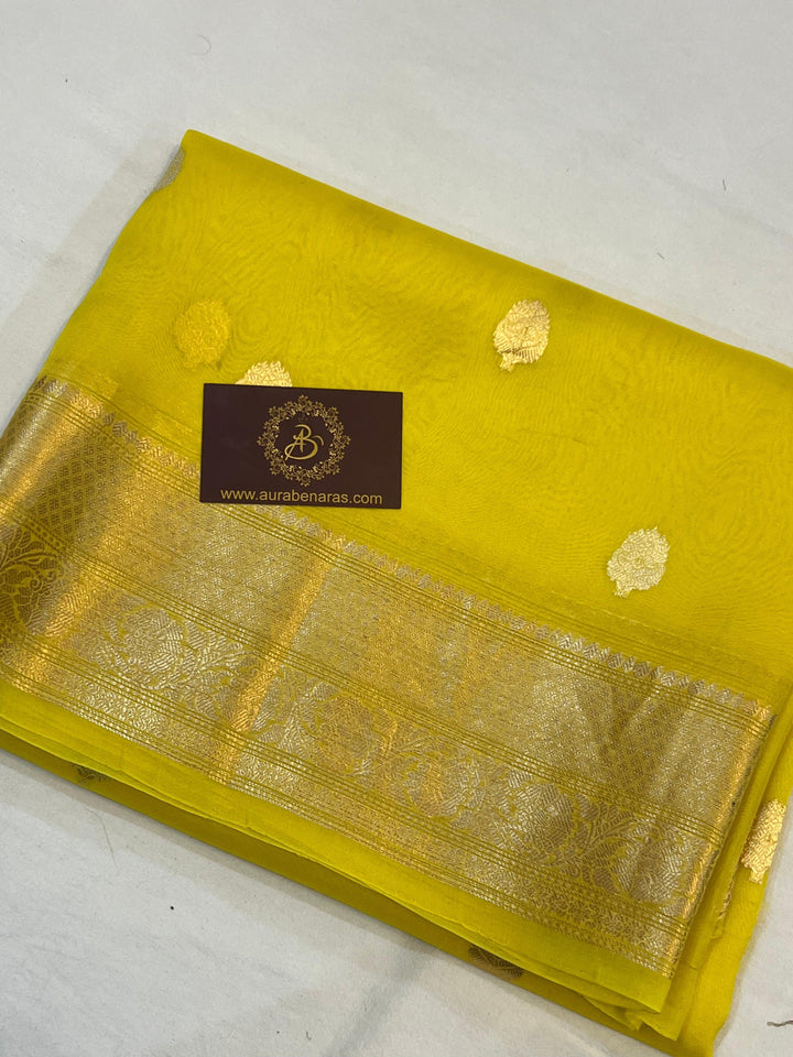Pure Banarasi handloom Kora silk saree by Aura Benaras, featuring intricate Kadhwa butas and a beautiful traditional Banarasi border—ideal for weddings, festive wear, and special occasions.