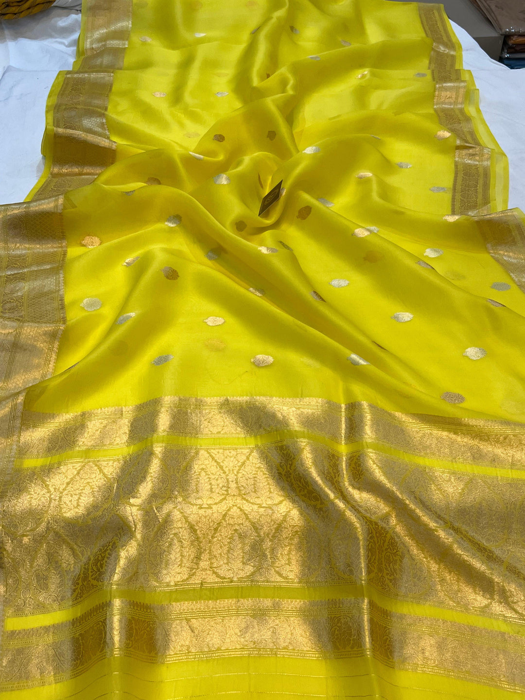 Pure Banarasi handloom Kora silk saree by Aura Benaras, featuring intricate Kadhwa butas and a beautiful traditional Banarasi border—ideal for weddings, festive wear, and special occasions.