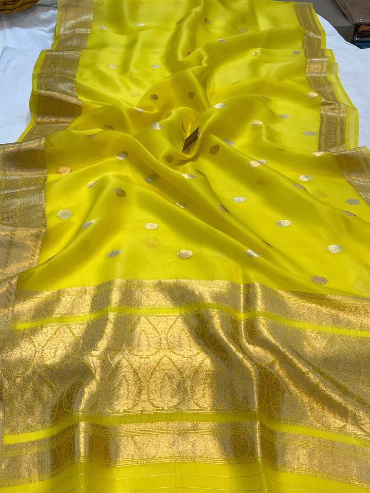 Pure Banarasi handloom Kora silk saree by Aura Benaras, featuring intricate Kadhwa butas and a beautiful traditional Banarasi border—ideal for weddings, festive wear, and special occasions.