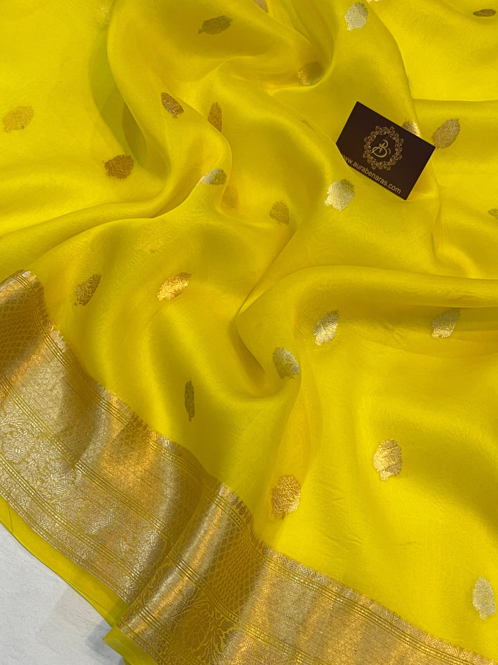 Pure Banarasi handloom Kora silk saree by Aura Benaras, featuring intricate Kadhwa butas and a beautiful traditional Banarasi border—ideal for weddings, festive wear, and special occasions.