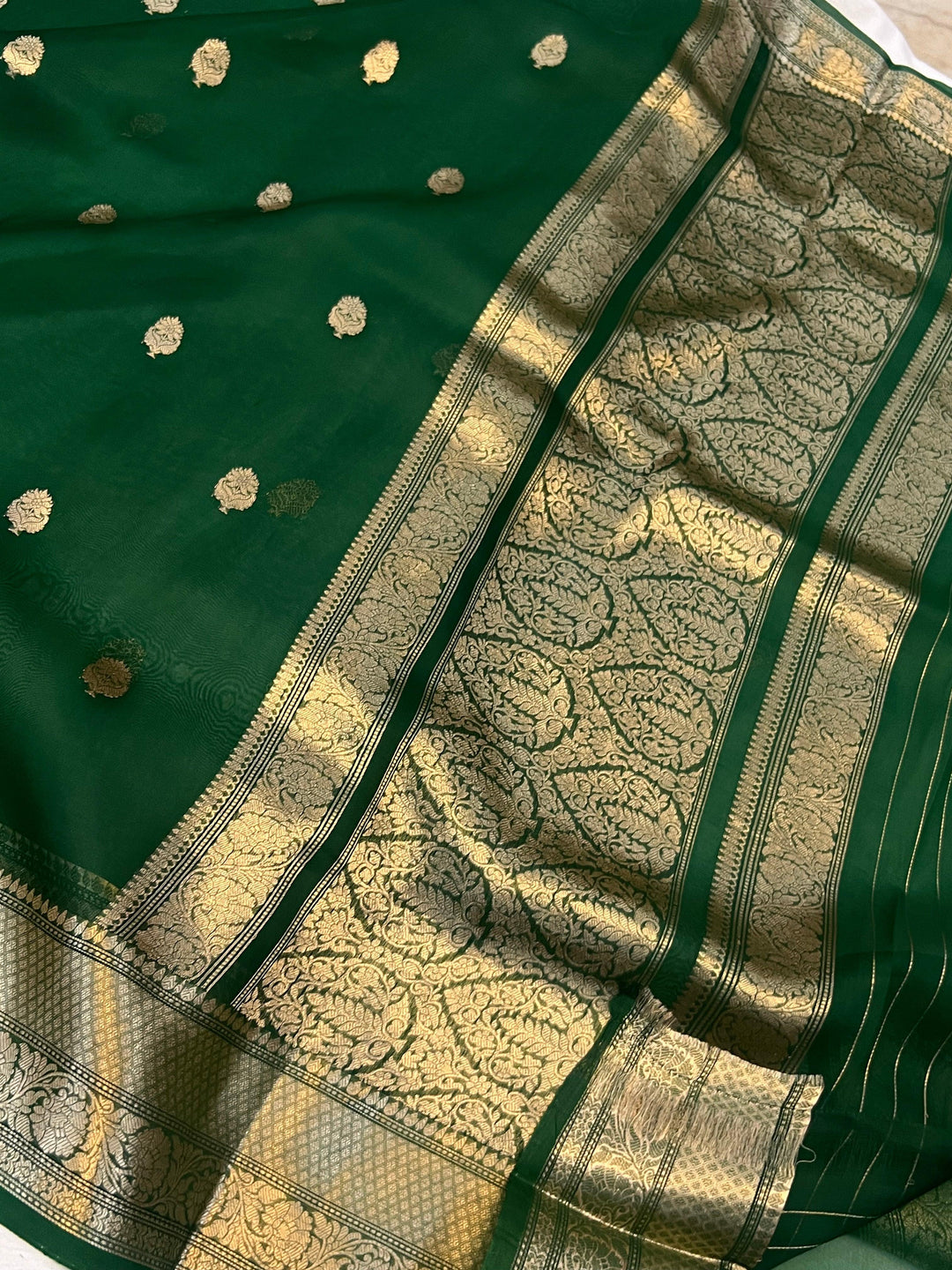 Pure Banarasi handloom Kora silk saree by Aura Benaras, featuring intricate Kadhwa butas and a beautiful traditional Banarasi border—ideal for weddings, festive wear, and special occasions.
