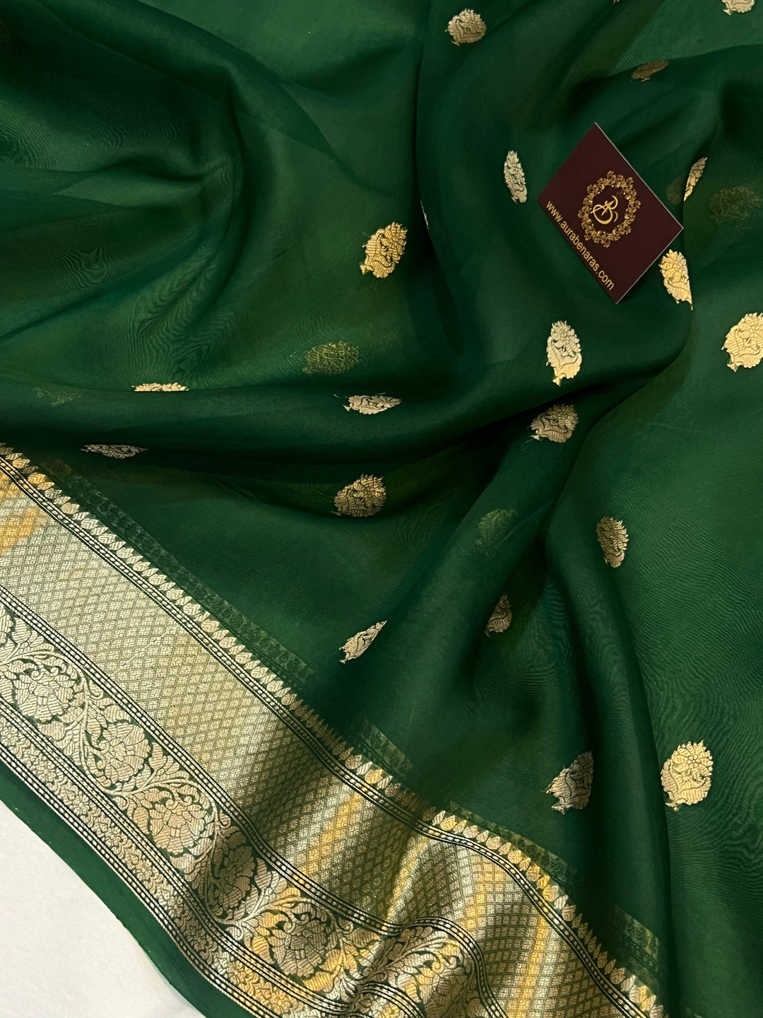Pure Banarasi handloom Kora silk saree by Aura Benaras, featuring intricate Kadhwa butas and a beautiful traditional Banarasi border—ideal for weddings, festive wear, and special occasions.