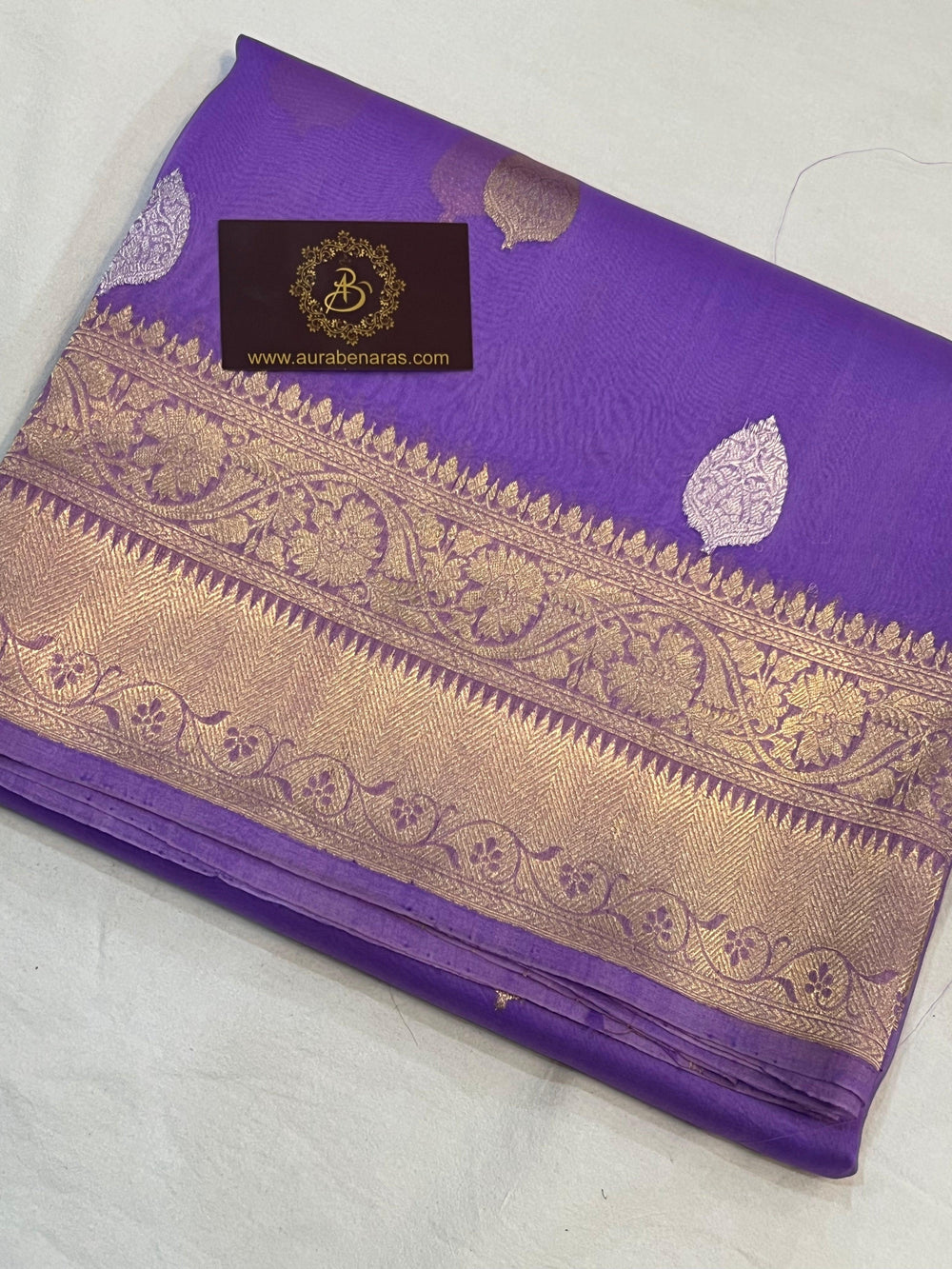 Pure Banarasi handloom Kora silk saree by Aura Benaras, featuring intricate Kadhwa butas and a beautiful traditional Banarasi border—ideal for weddings, festive wear, and special occasions.
