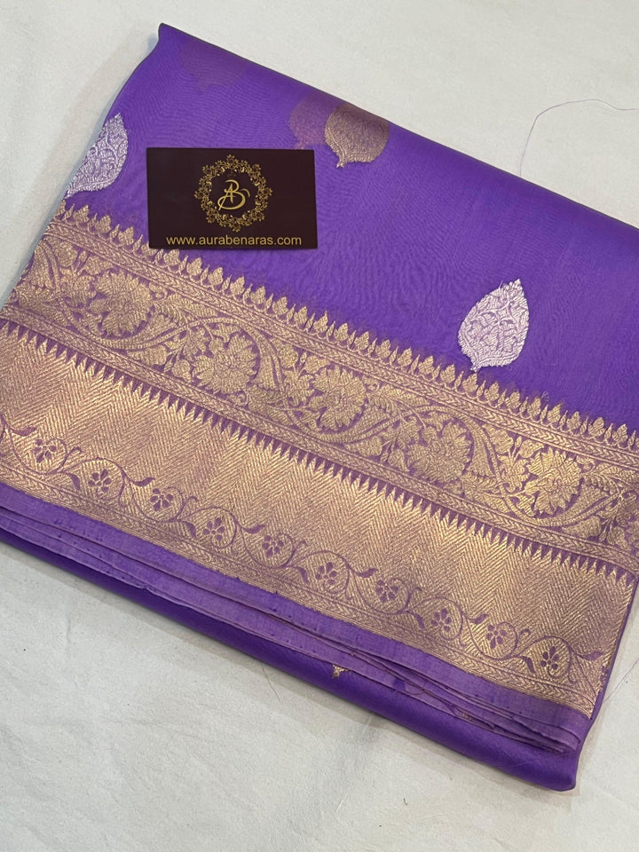 Pure Banarasi handloom Kora silk saree by Aura Benaras, featuring intricate Kadhwa butas and a beautiful traditional Banarasi border—ideal for weddings, festive wear, and special occasions.