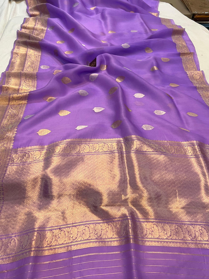 Pure Banarasi handloom Kora silk saree by Aura Benaras, featuring intricate Kadhwa butas and a beautiful traditional Banarasi border—ideal for weddings, festive wear, and special occasions.
