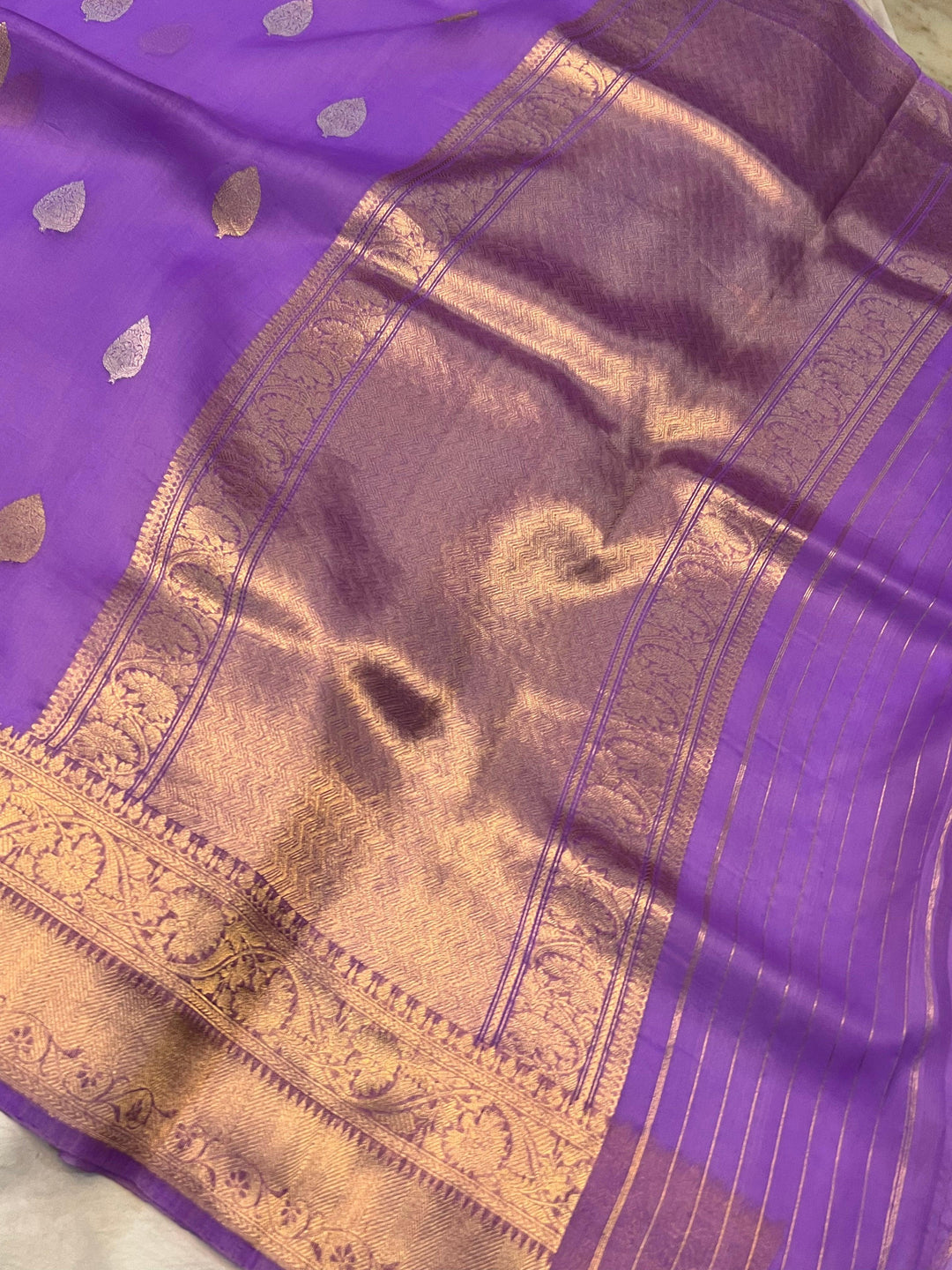 Pure Banarasi handloom Kora silk saree by Aura Benaras, featuring intricate Kadhwa butas and a beautiful traditional Banarasi border—ideal for weddings, festive wear, and special occasions.