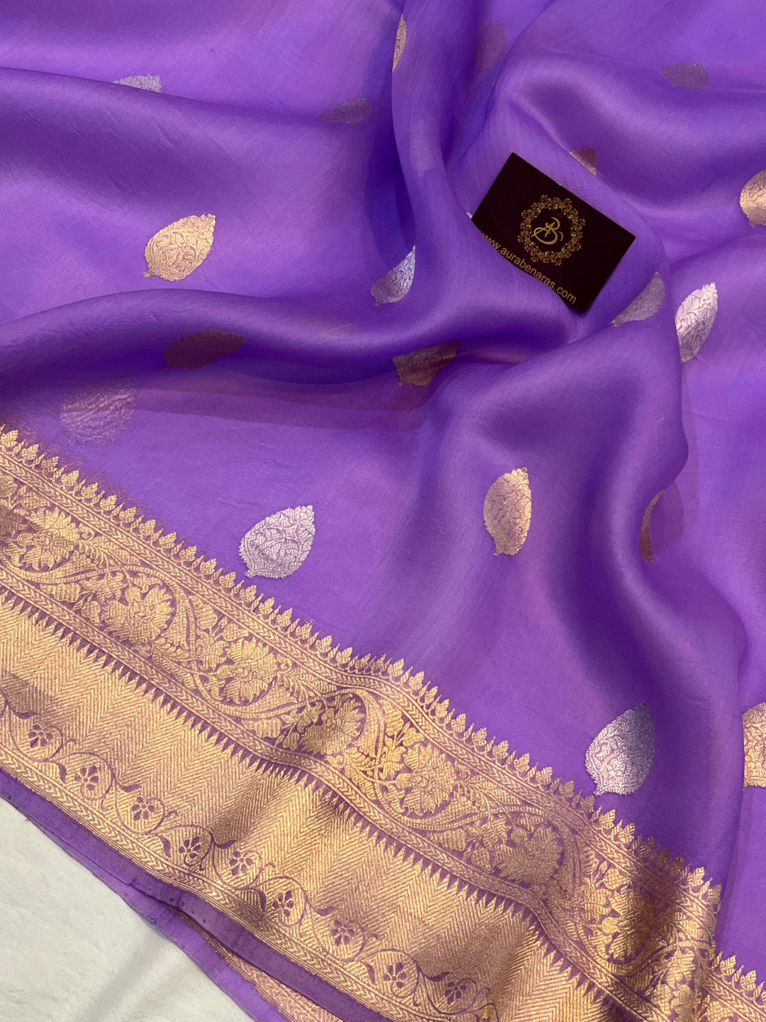 Pure Banarasi handloom Kora silk saree by Aura Benaras, featuring intricate Kadhwa butas and a beautiful traditional Banarasi border—ideal for weddings, festive wear, and special occasions.
