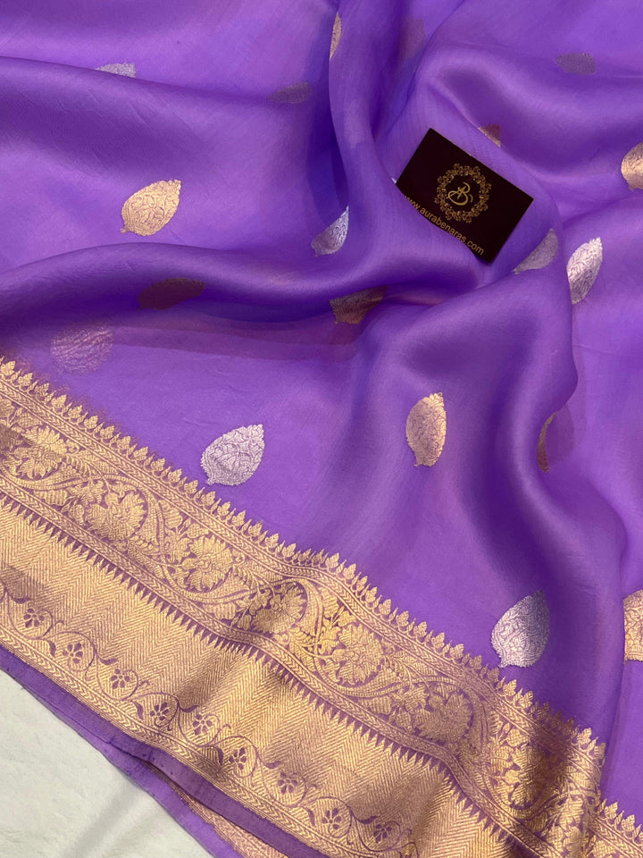 Pure Banarasi handloom Kora silk saree by Aura Benaras, featuring intricate Kadhwa butas and a beautiful traditional Banarasi border—ideal for weddings, festive wear, and special occasions.