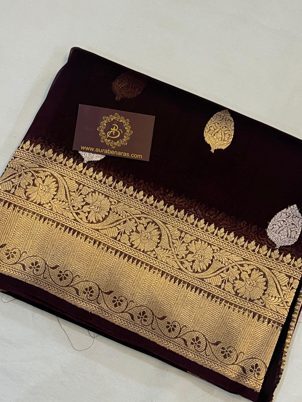 Pure Banarasi handloom Kora silk saree by Aura Benaras, featuring intricate Kadhwa butas and a beautiful traditional Banarasi border—ideal for weddings, festive wear, and special occasions.