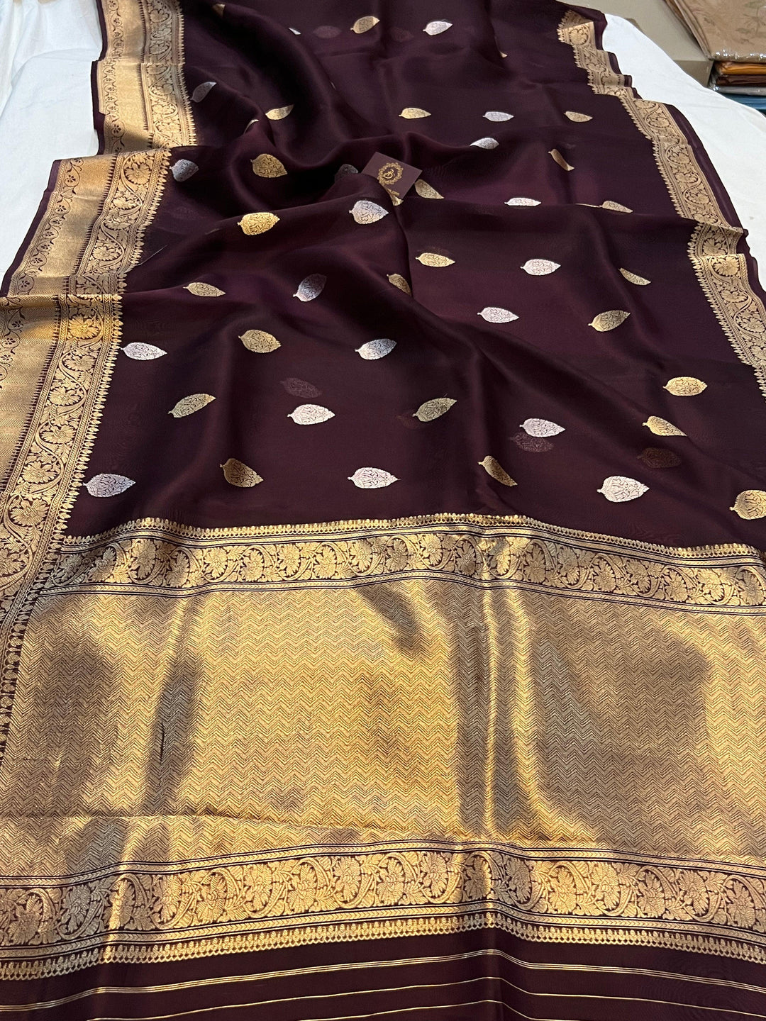 Pure Banarasi handloom Kora silk saree by Aura Benaras, featuring intricate Kadhwa butas and a beautiful traditional Banarasi border—ideal for weddings, festive wear, and special occasions.