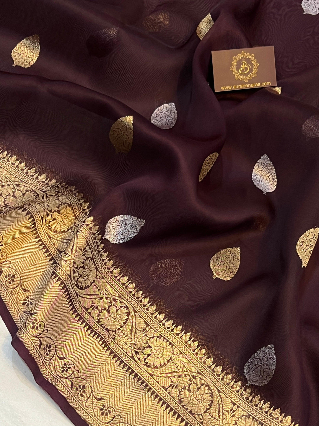 Pure Banarasi handloom Kora silk saree by Aura Benaras, featuring intricate Kadhwa butas and a beautiful traditional Banarasi border—ideal for weddings, festive wear, and special occasions.