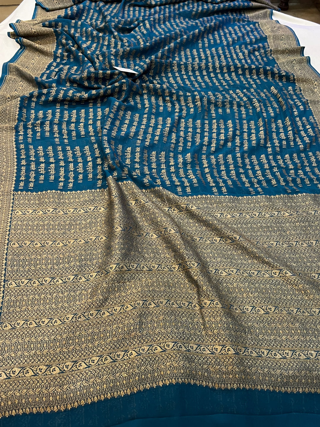 Teal Blue Pure Banarasi Khaddi Georgette saree with antique zari and Sanskrit shloka motifs