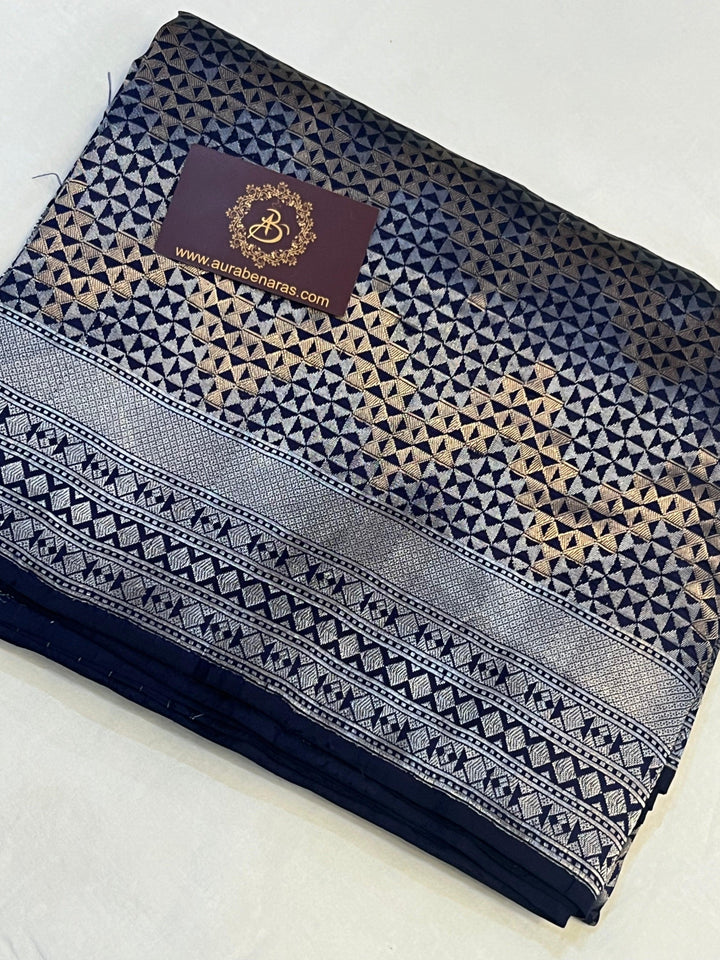 Folded view of pure Katan silk Banarasi saree showcasing the silver geometric brocade and golden zig-zag design