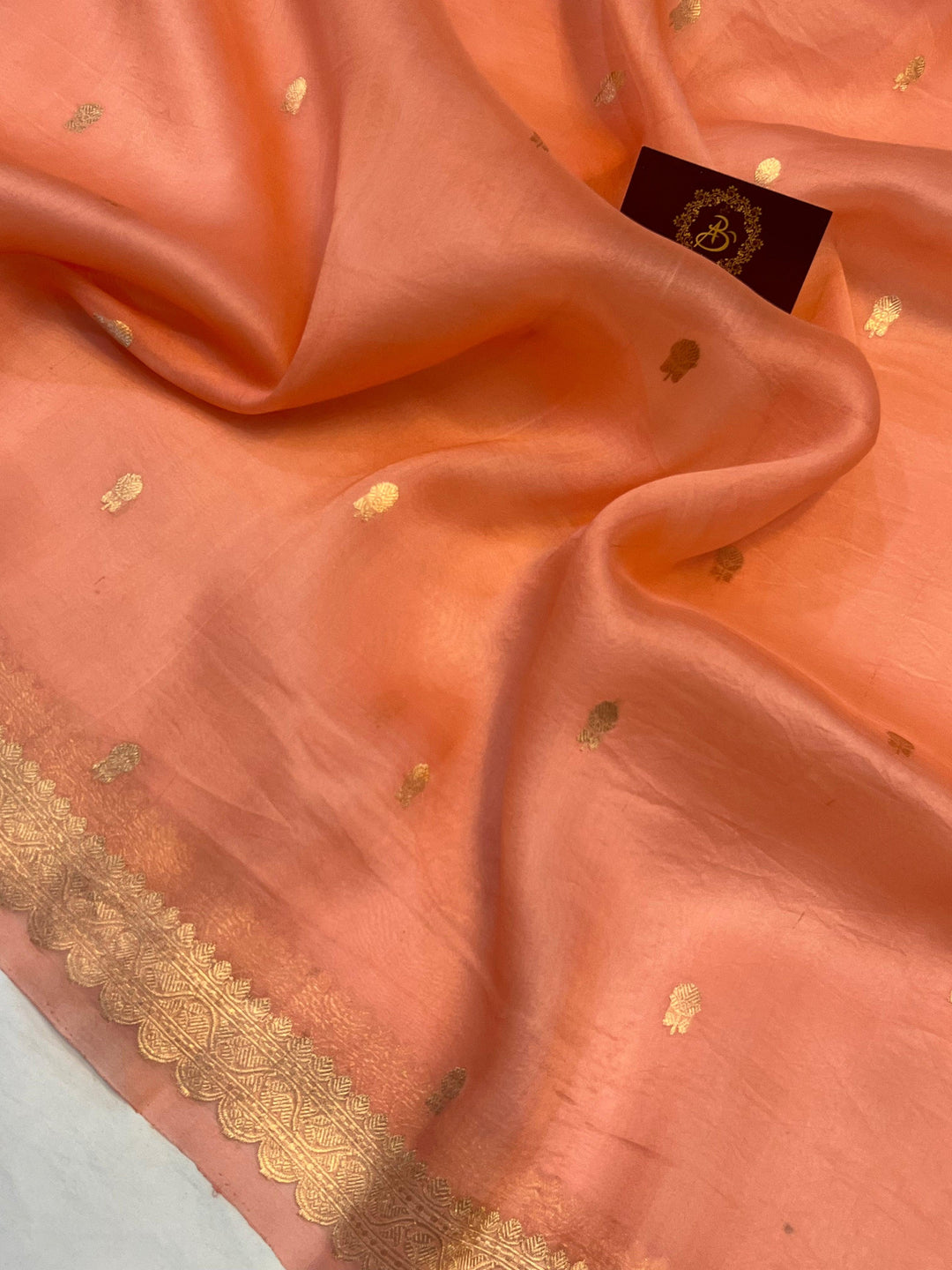 Detailed view of small golden zari butis on sheer Kora silk fabric, showcasing traditional Kadhwa weaving