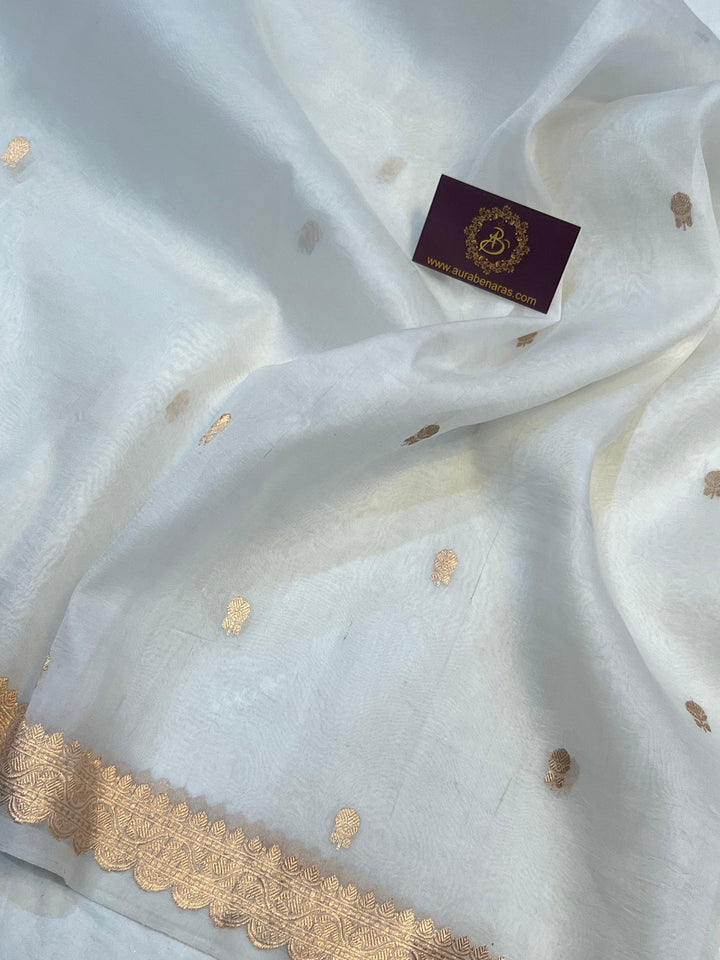 Detailed view of small golden zari butis on sheer Kora silk fabric, showcasing traditional Kadhwa weaving