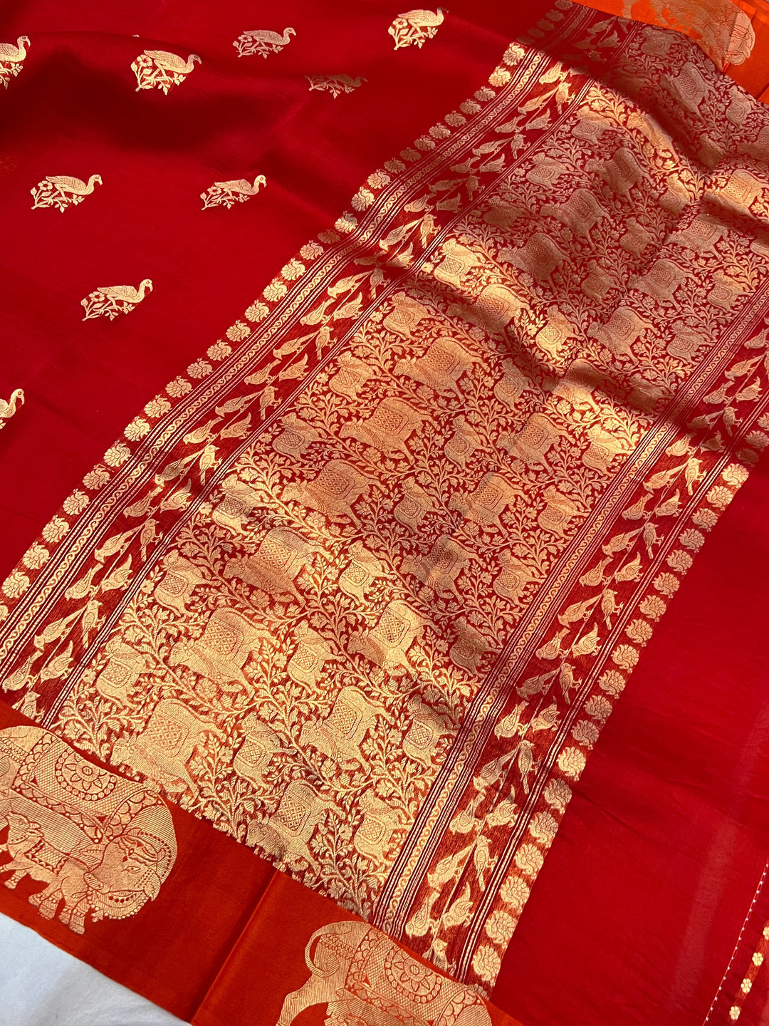 Reddish Orange Kora Silk Banarasi Saree | Cow Motif Border