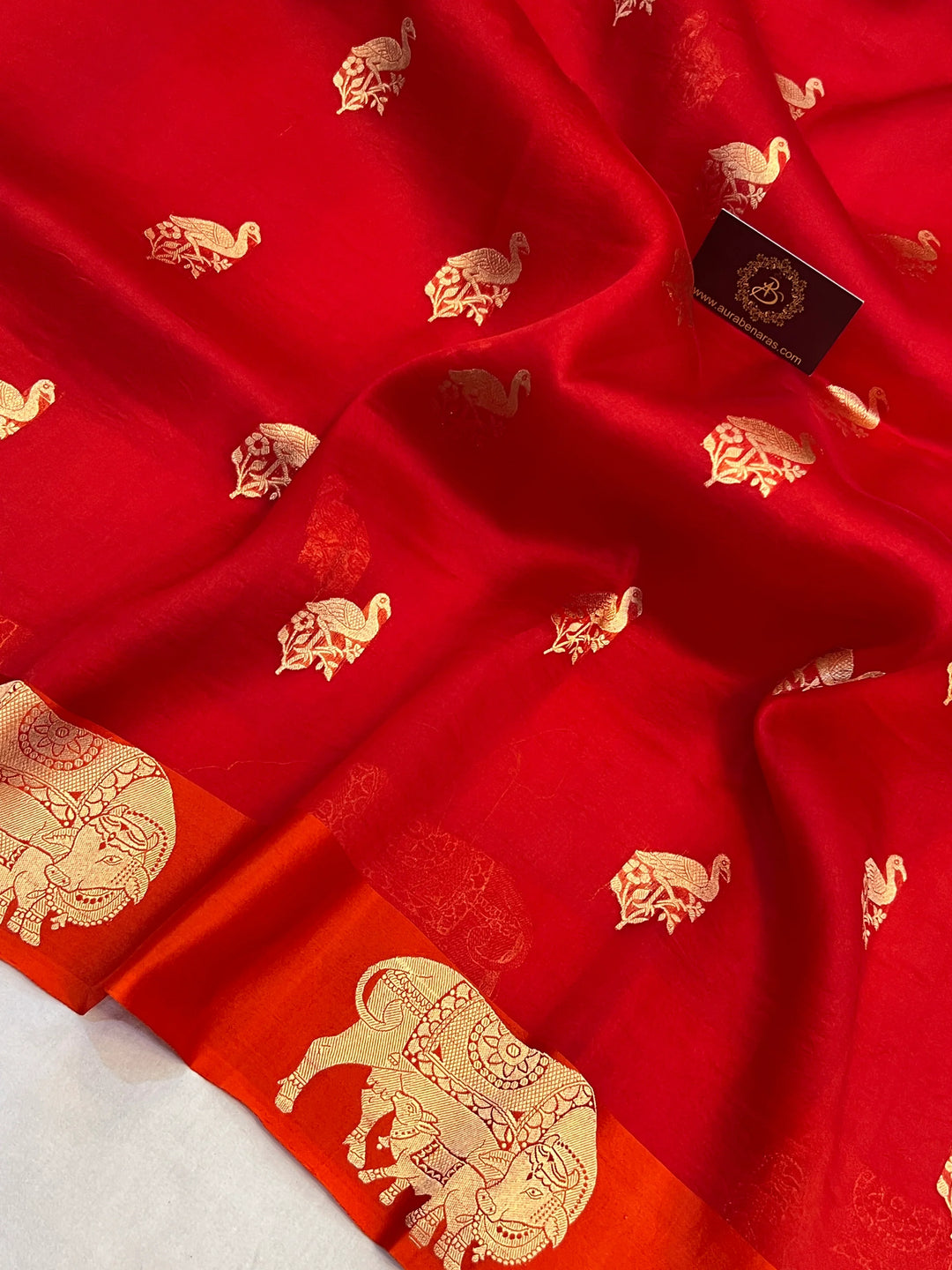 Reddish Orange Kora Silk Banarasi Saree | Cow Motif Border