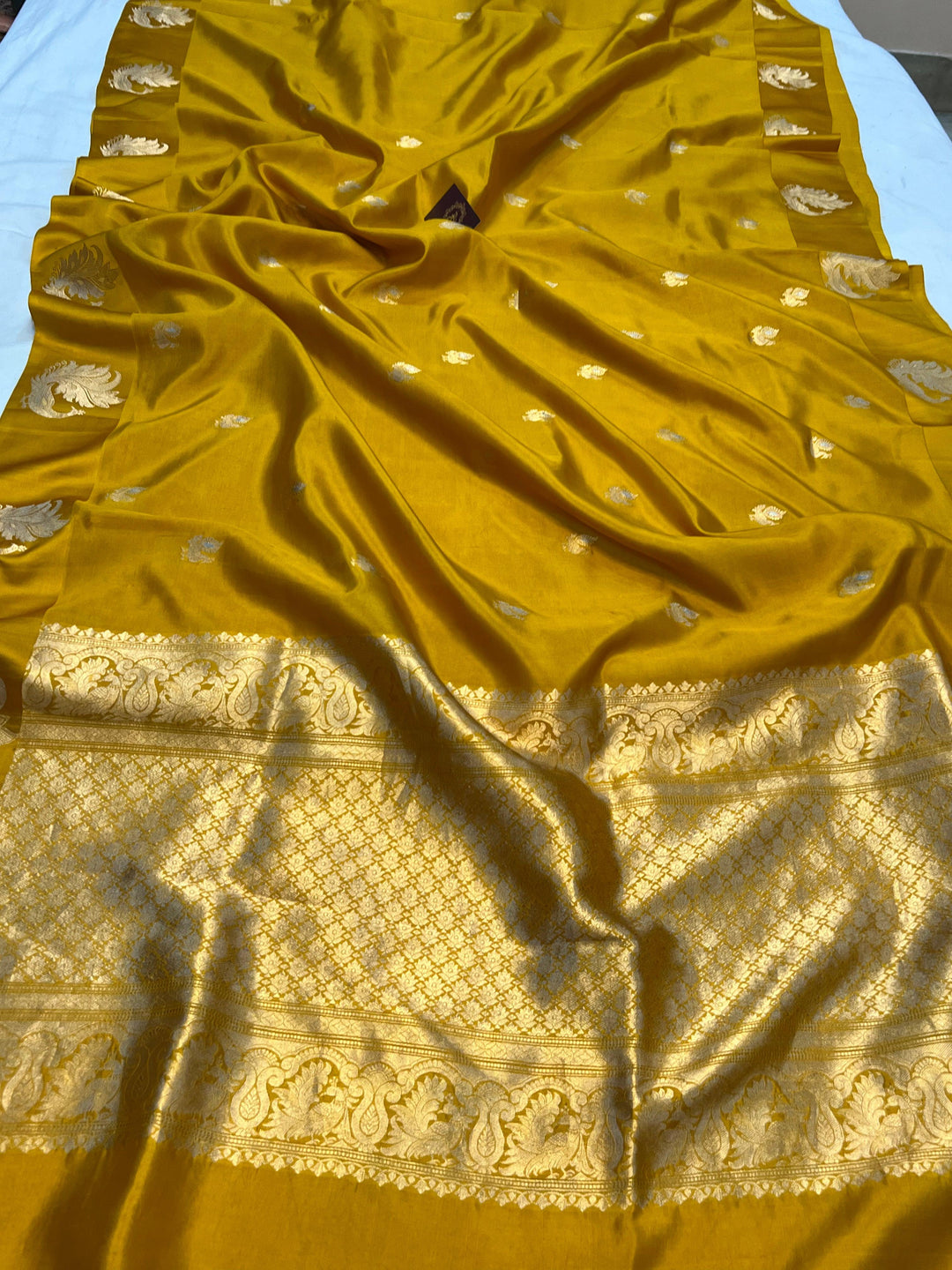Pure silk handloom Banarasi saree with golden zari Kadhwa motifs and Mashru silk border featuring animal designs