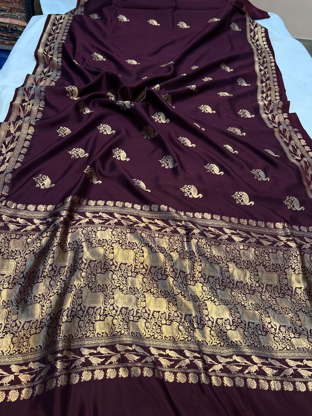 Pure silk handloom Banarasi saree with golden zari Kadhwa motifs and Mashru silk border featuring animal designs