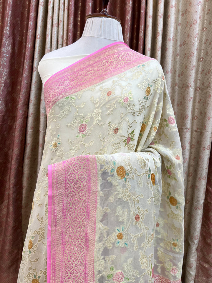 Pure Banarasi khaddi georgette saree draped with light golden zari jaal work and vibrant handbrush rangkaat motifs