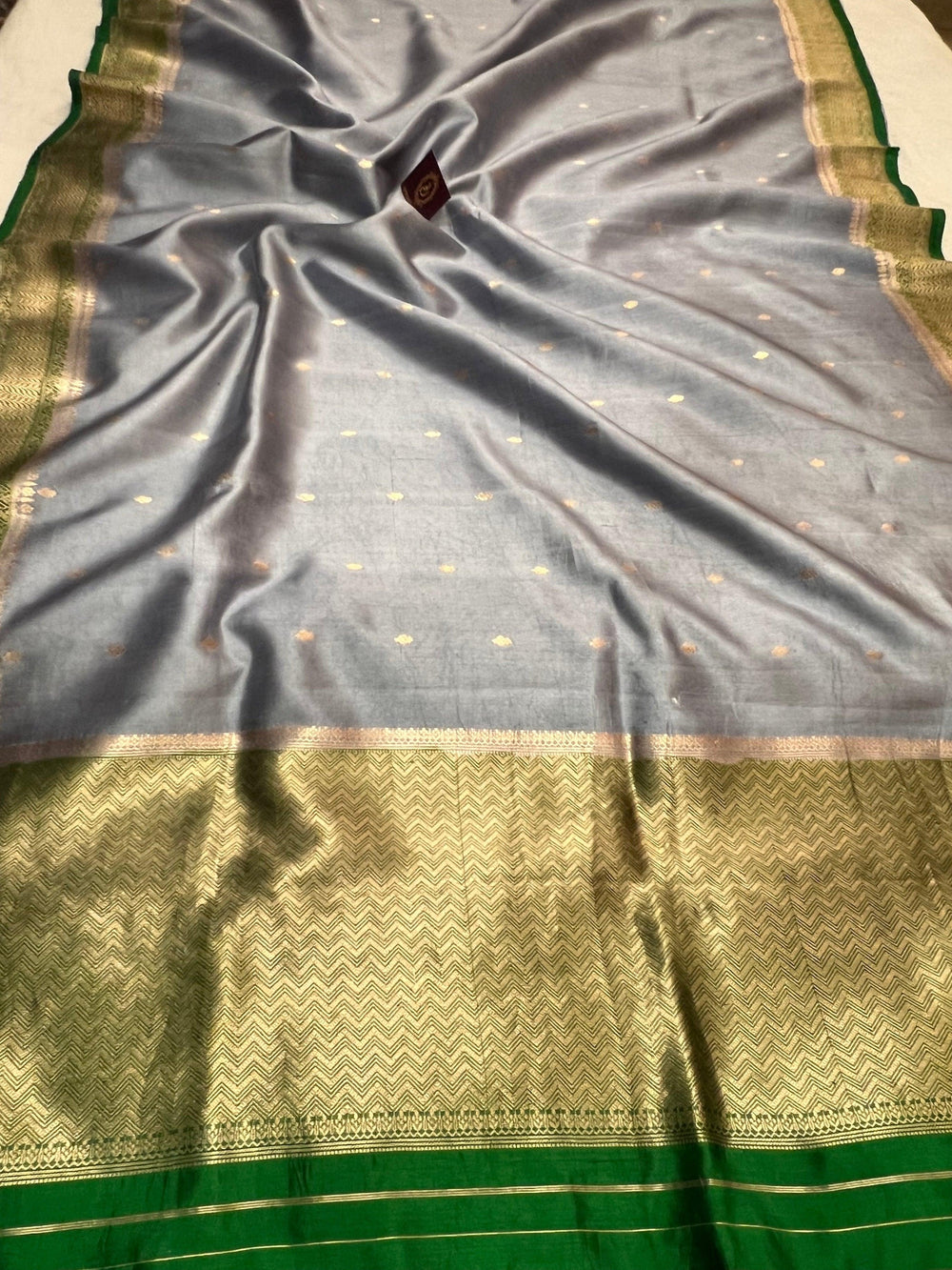 Pure silk handloom Banarasi saree draped with contrast Kadhwa borders and butis, featuring elegant handwoven craftsmanship