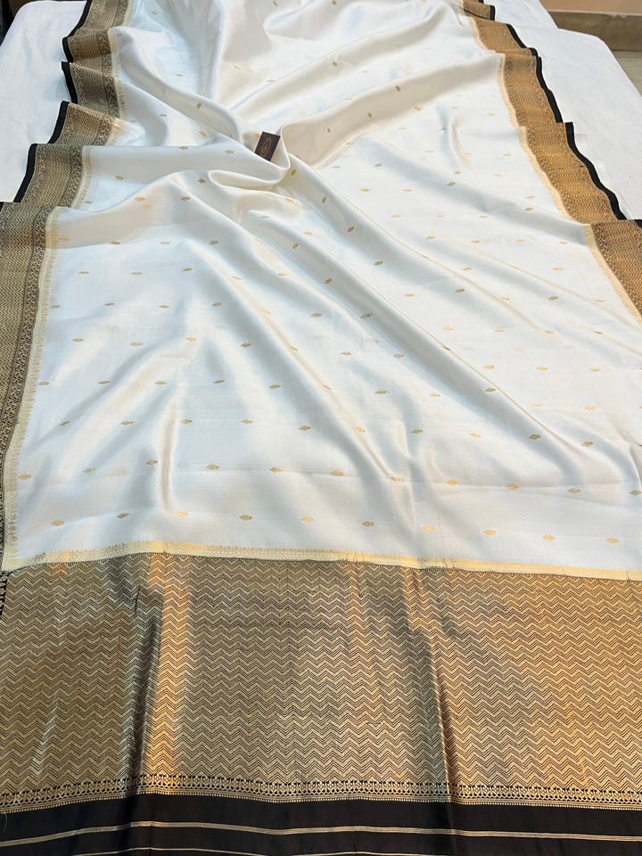 Pure silk handloom Banarasi saree draped with contrast Kadhwa borders and butis, featuring elegant handwoven craftsmanship