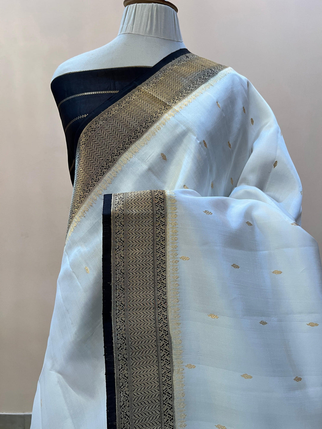 Pure silk handloom Banarasi saree draped with contrast Kadhwa borders and butis, featuring elegant handwoven craftsmanship
