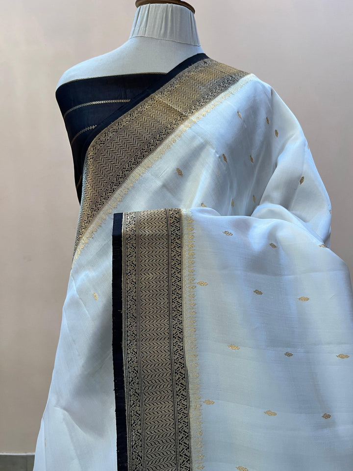 Pure silk handloom Banarasi saree draped with contrast Kadhwa borders and butis, featuring elegant handwoven craftsmanship