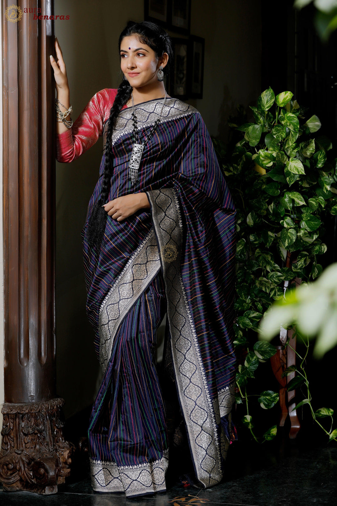 Woman wearing traditional pure Katan silk Banarasi saree with stripe work and Kadhwa border, ideal for weddings or festive wear