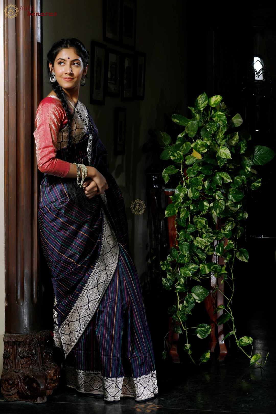 Woman wearing traditional pure Katan silk Banarasi saree with stripe work and Kadhwa border, ideal for weddings or festive wear